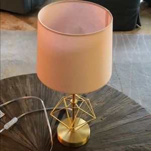 A lamp with a pink lamp shade